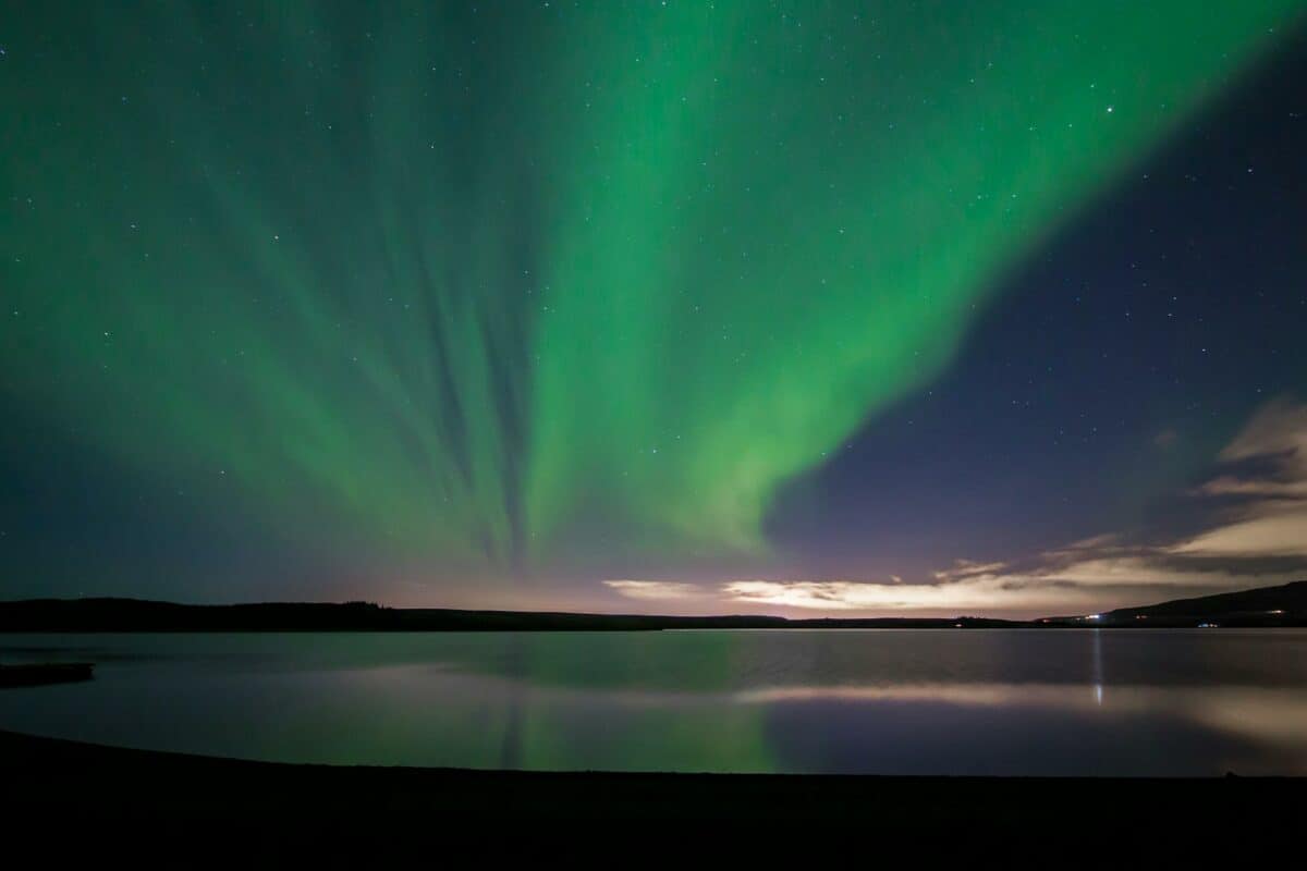 the view of the northern lights in hafravatn lake in iceland