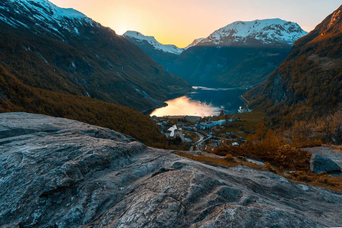 a sunset over a lake in the mountains